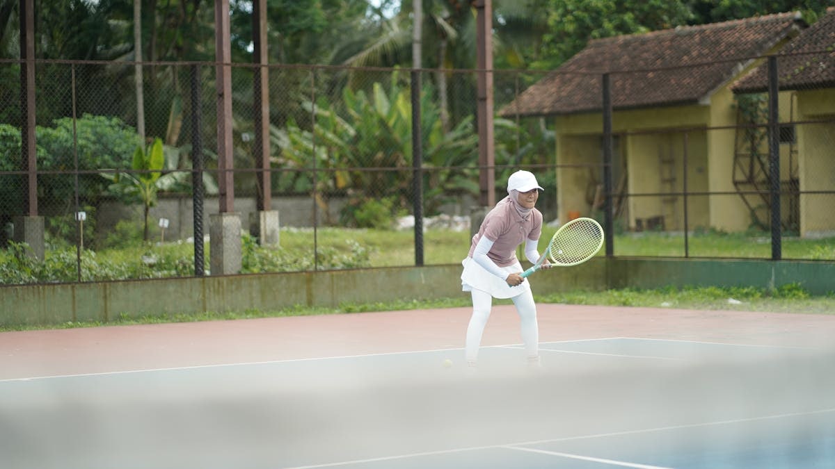 A focused tennis player poised on an outdoor court, capturing the dynamic nature of the sport.